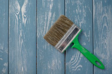 Mavi ahşap bir masa üzerinde boya fırçası.