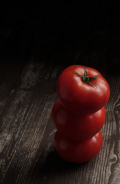 Koyu ahşap bir masa üzerinde taze domates — Stok fotoğraf