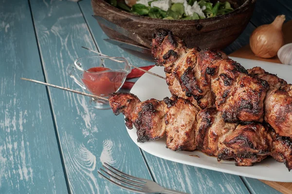 Shashlik com salada na mesa de madeira . — Fotografia de Stock