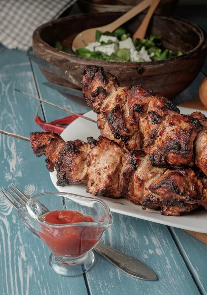 Shashlik com salada na mesa de madeira . — Fotografia de Stock