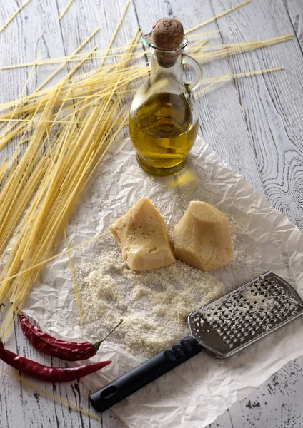 Grated parmesan cheese, bottle of olive oil and metal grater on — Stock Photo, Image
