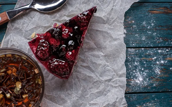 一张莓果馅饼和一杯茶在一个木制的背景 — 图库照片