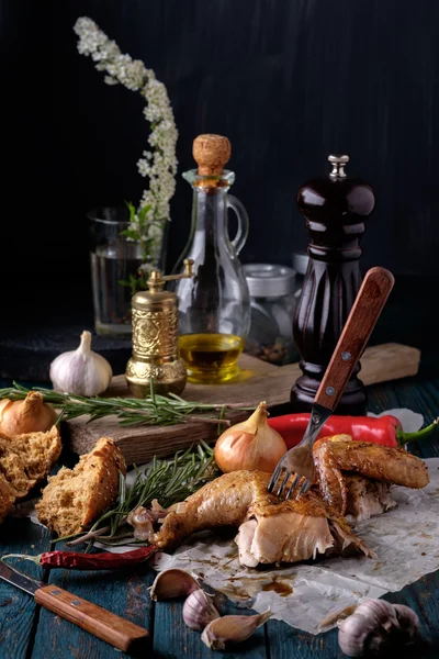 Roasted chicken leg and wing with spices and herbs on a wooden t — Stock Photo, Image