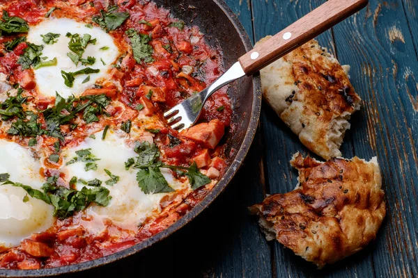 Huevos fritos en una sartén con tomates, salchichas y verduras — Foto de Stock