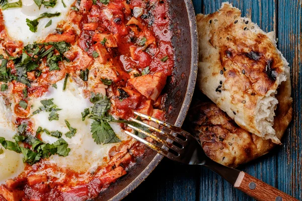 Huevos fritos en una sartén con tomates, salchichas y verduras — Foto de Stock