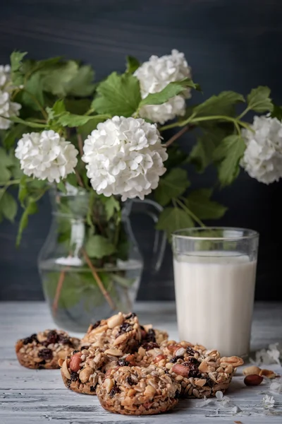 Glas Milch und Kekse aus Nüssen und Rosinen — Stockfoto