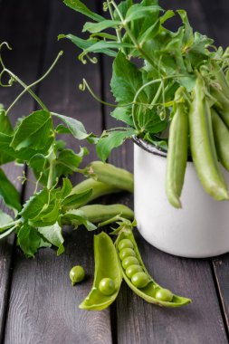 Ahşap masa üzerinde olgunlaşmış yeşil bezelye.