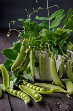 Ahşap masa üzerinde olgunlaşmış yeşil bezelye.