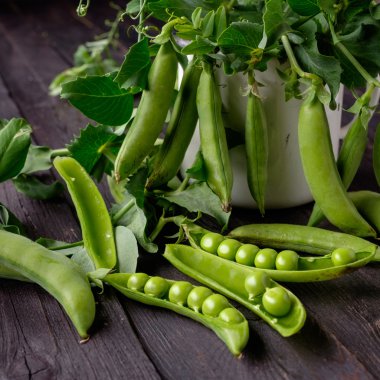 Ahşap masa üzerinde olgunlaşmış yeşil bezelye.