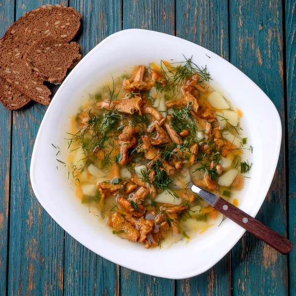 Sup dengan chanterelles, herbal dan kentang di latar belakang kayu . — Stok Foto