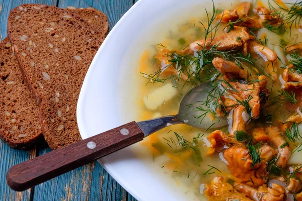 Sup dengan chanterelles, herbal dan kentang di latar belakang kayu . — Stok Foto