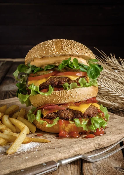 Gran hamburguesa sabrosa con carne de res y patatas fritas . —  Fotos de Stock