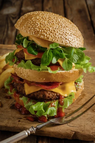 Gran hamburguesa sabrosa con carne de res y patatas fritas . —  Fotos de Stock