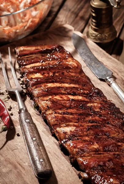 Deliziose costolette barbecue con insalata di cavolo sul tavolo di legno — Foto Stock