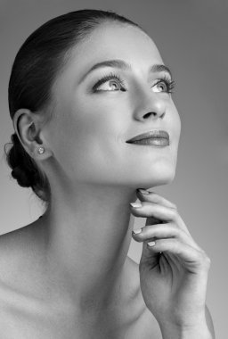 Güzel kadın boynuna dokunuyor.