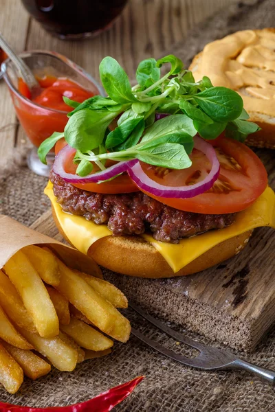 Home made burger and chips on wooden background