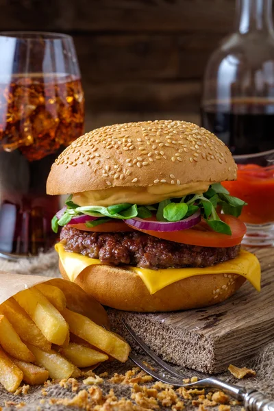 Delizioso hamburger con patatine e soda sul tavolo di legno . — Foto Stock
