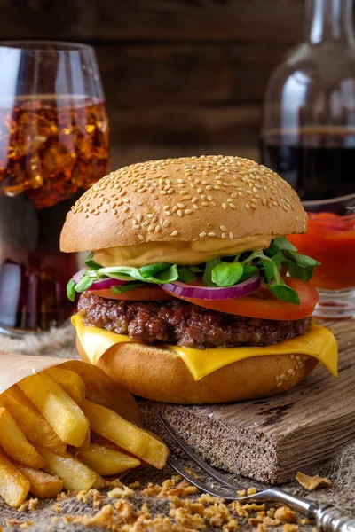 Delicioso hambúrguer com batatas fritas e refrigerante na mesa de madeira . — Fotografia de Stock