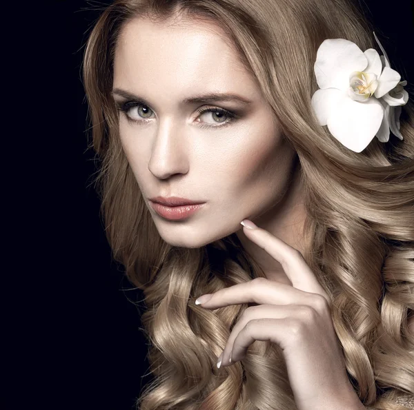 Beautiful blonde with long wavy hair touching face — Stock Photo, Image