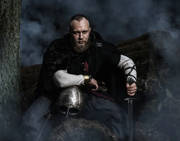 Viking com espada e capacete em um fundo de floresta fumegante — Fotografia de Stock