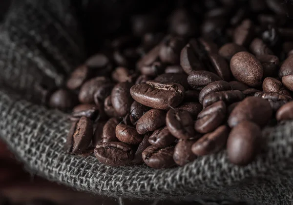 Saco de grãos de café em um fundo escuro . — Fotografia de Stock