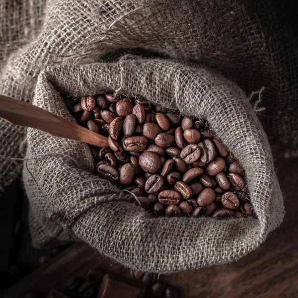 Saco de grãos de café em um fundo escuro . — Fotografia de Stock