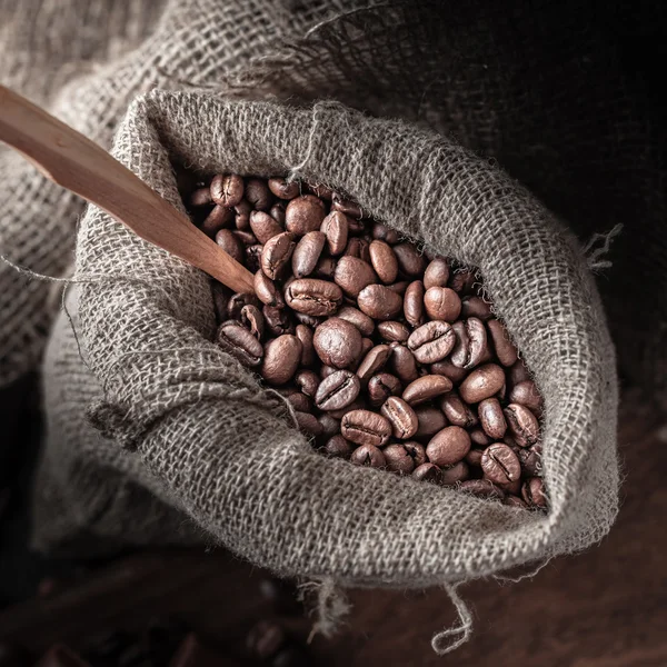 Saco de grãos de café em um fundo escuro . — Fotografia de Stock
