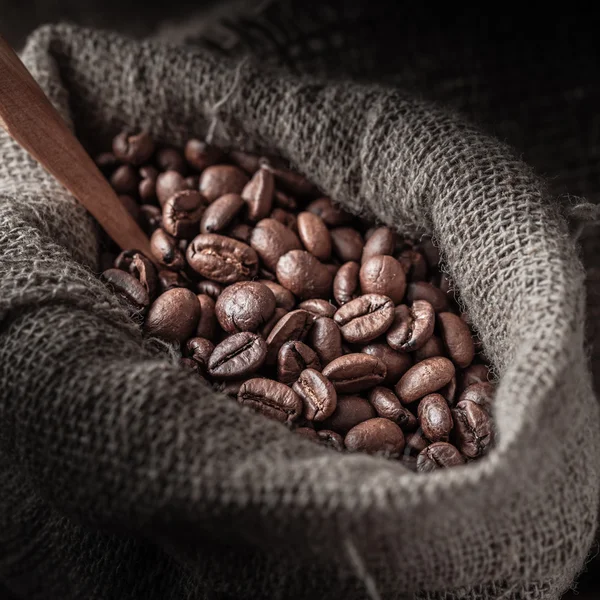 Saco de grãos de café em um fundo escuro . — Fotografia de Stock