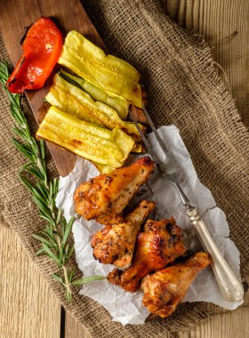 Bir rustik ahşap tabloda sebzeli soslu Barbekü kanat