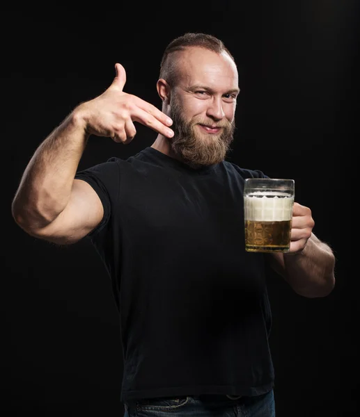 Uomo barbuto in piedi con una tazza di birra leggera — Foto Stock