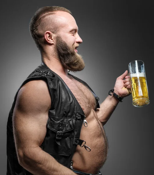 Motociclista sonriente con barriga de cerveza. El hombre bebe cerveza de una taza —  Fotos de Stock