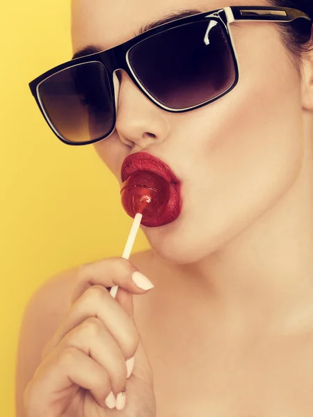 Bella donna sorridente sexy stupefacente in occhiali da sole con un lecca-lecca — Foto Stock