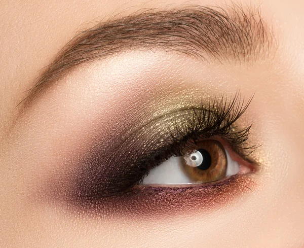 Maquillaje de ojos con sombra de ojos marrón dorado de moda brillante . — Foto de Stock