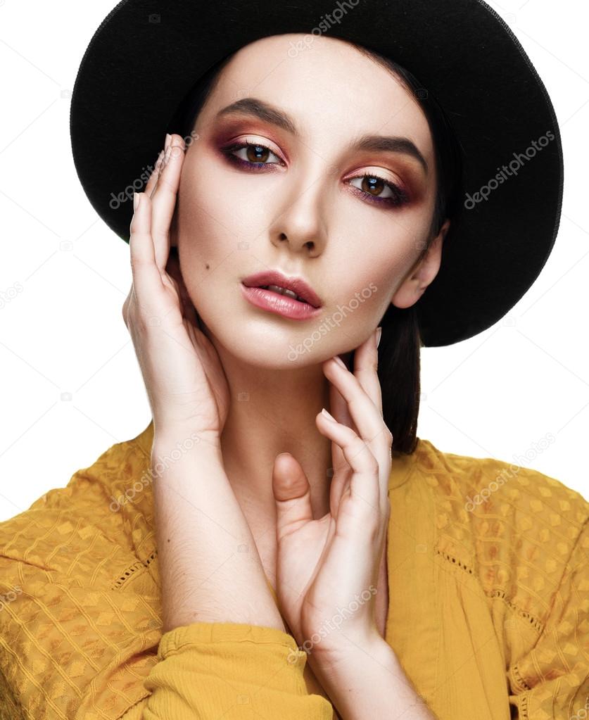 Portrait of a beautiful girl in the hat on a white background