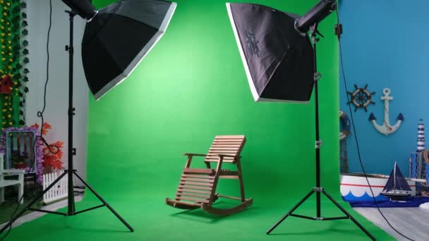 Studio fotograficzne lub wideo z dwoma sześciokątnymi lampami studyjnymi. Zielony ekran i fotel bujany — Wideo stockowe