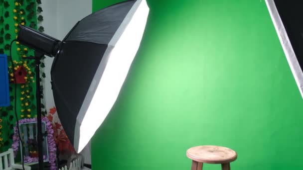 Фото или видео студия с двумя гексагоновыми огнями студии. Зеленый экран и кресло — стоковое видео