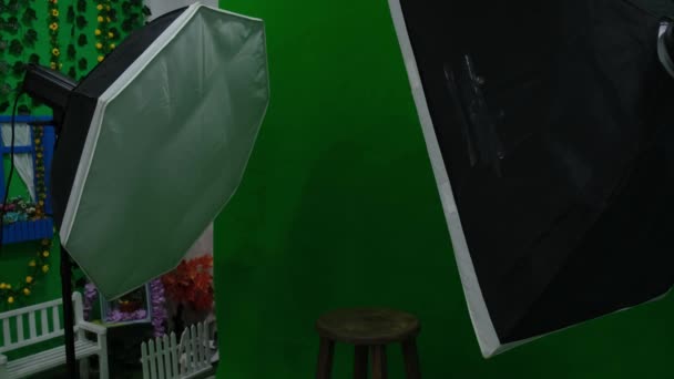 Fotografické nebo video studio se dvěma šestihrannými studiovými světly. Zelená obrazovka a pevná židle — Stock video