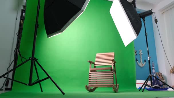 Фото или видео студия с двумя гексагоновыми огнями студии. Зеленый экран и кресло-качалка — стоковое видео