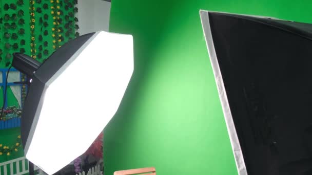 Фото или видео студия с двумя гексагоновыми огнями студии. Зеленый экран и кресло — стоковое видео