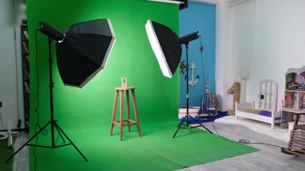 Foto- oder Videostudio mit zwei sechseckigen Studioleuchten. Sanduhr auf grünem Vorhang und festem Stuhl — Stockvideo