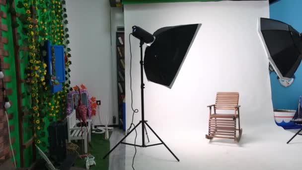 Фото или видео студия с двумя гексагоновыми огнями студии. Белый экран и кресло — стоковое видео