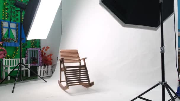 Photo or video studio with two hexagone studio lights. White screen and rocking chair — Stock Video