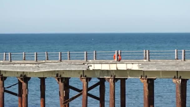 Bølger bevæger sig mellem søjlerne i havet molen. 4k stabil skydning – Stock-video