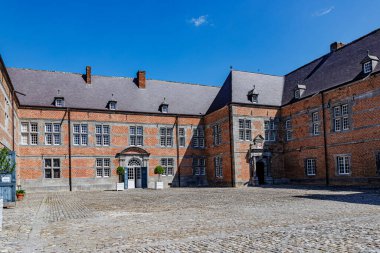 Freyr Kalesi 'nin girişi Rönesans tarzı bina, kaldırım taşı zemin, tuğla duvarlar, birden fazla pencere, iki giriş kapısı ve açık çatı Namur, Wallonia, Belçika' da güneşli bir yaz günü.