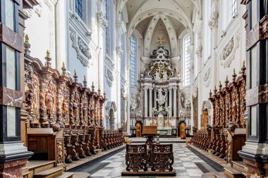 Averbode, Scherpenheuvel-Zichem, Belçika. 19 Eylül 2025. Manastır Kilisesi 'nin içindeki papaz evi ruhban sınıfı, sunaklar ve dini figürler için barok tarzı ahşap sıralar, büyük tırtıklı mahzenler ve sütunlar.