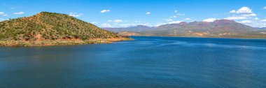 Arizona 'nın Sonoran Çölü' ndeki Roosevelt Gölü Panoraması. Arizona Tonto Ulusal Ormanı 'nın Salt River üzerindeki yapay Theodore Roosevelt Gölü' nün panonamik görüntüsü. Birçok saguaro kaktüsü berrak mavi rezervuar suyuna yakın.. 