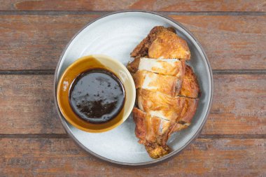 Kızarmış tavuk beyaz tabakta üzerinde ahşap bir masa ayarla