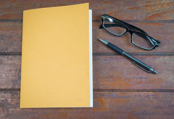 Cuaderno de sobrecarga con bolígrafo y gafas sobre fondo de madera — Foto de Stock