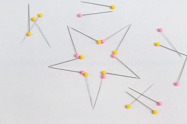 Beaucoup de broches pour le travail de l'aiguille sur tissu blanc — Photo