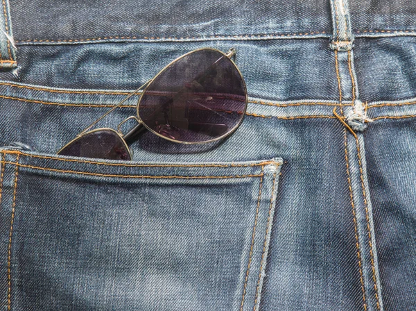 牛仔裤贴图，蓝色的牛仔裤，带着太阳眼镜 — 图库照片